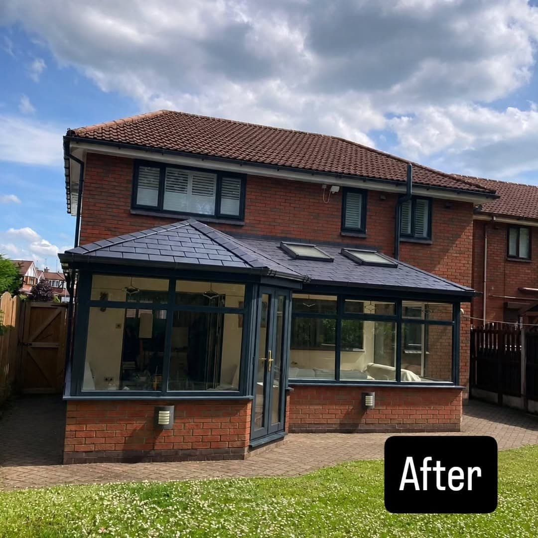 The same conservatory after conversion, with a new grey tiled warm roof and two Velux roof windows, matching the anthracite frames below